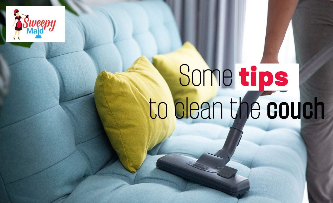 Bright blue sofa with yellow pillows and vacuum cleaner, tip for cleaning the couch effectively.